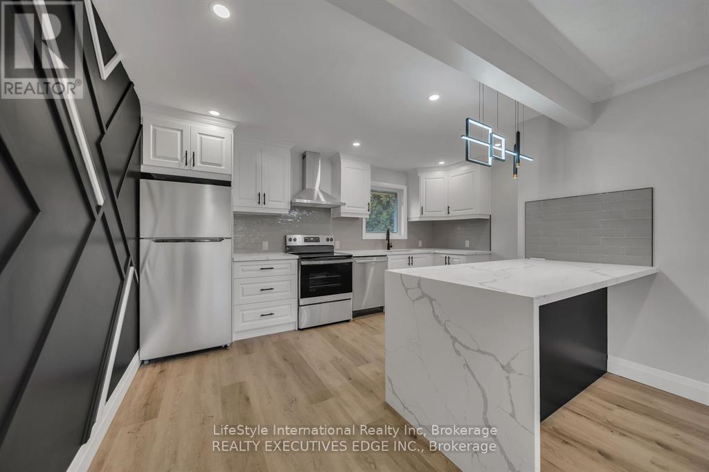 A modern kitchen with a white marble island and wooden flooring.