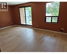 A room with wooden flooring and a large window.