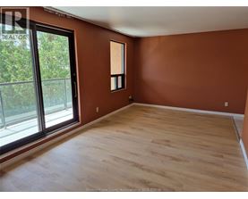 A room with wooden flooring and a large window.