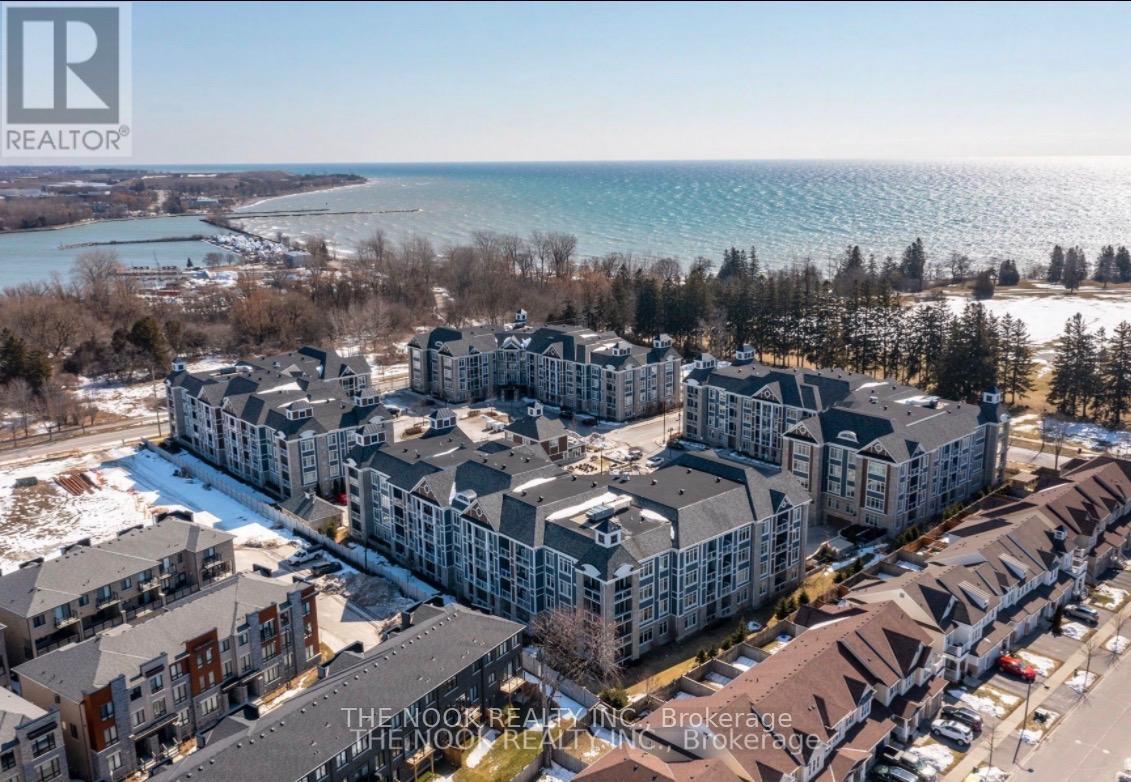 A bird's eye view of a residential area with apartment buildings and a body of water in the background.