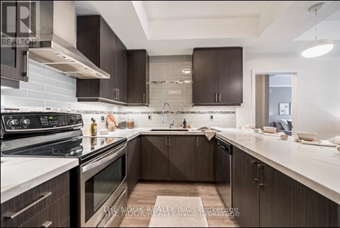 A modern kitchen with dark brown cabinets and stainless steel appliances.