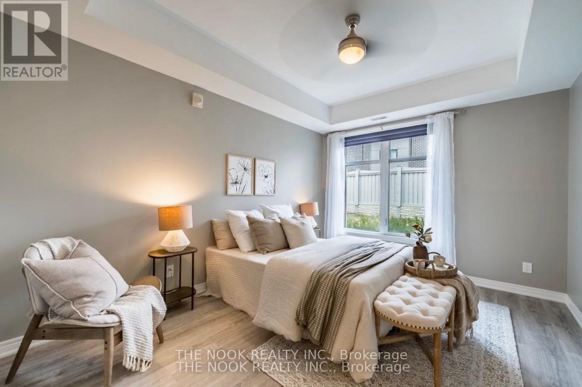 A bedroom with a bed, chair, and lamp.