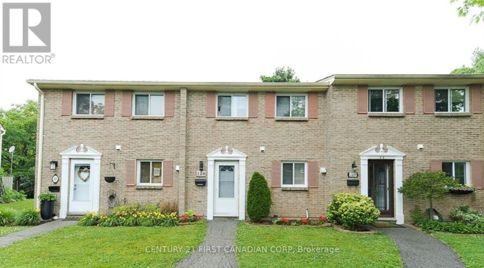 A building with a lawn in front and a sign that says Century 21 First Canadian Corp. Brokerage.