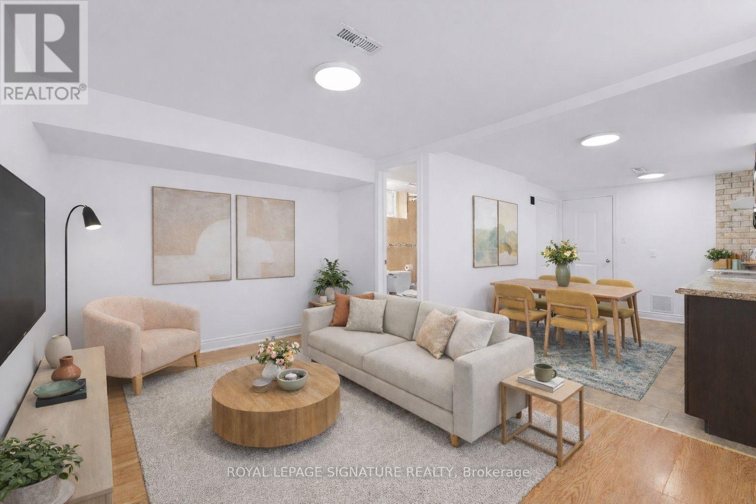 A living room with a white couch, a coffee table, and a dining table.