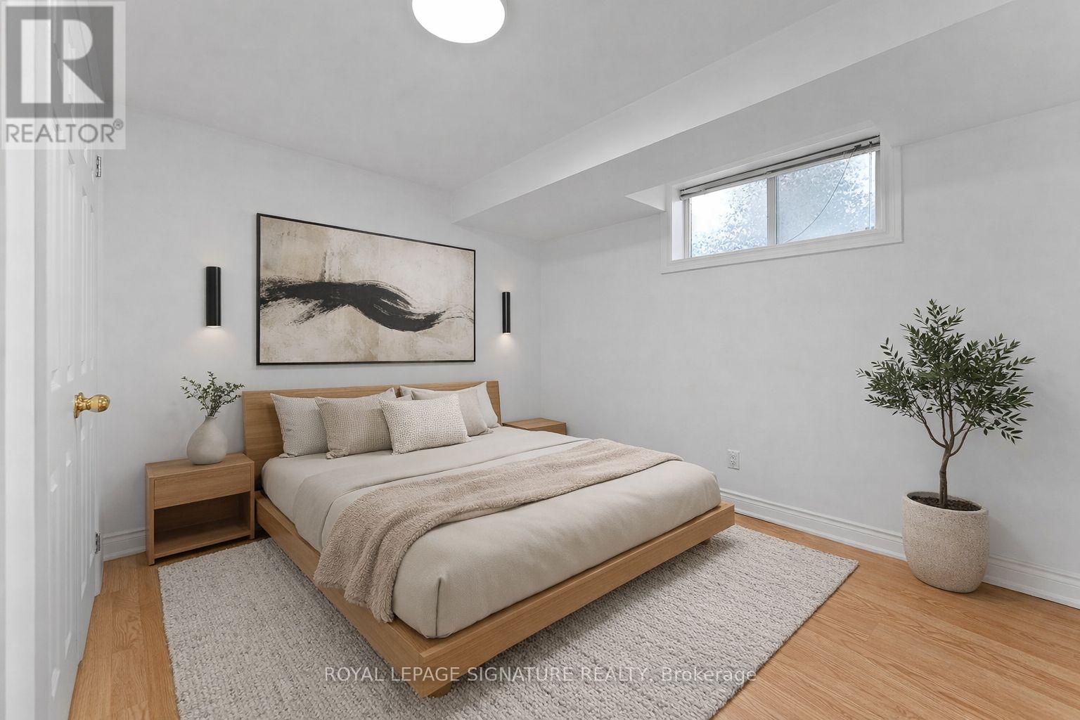 A bedroom with a bed, nightstand, and a painting on the wall.