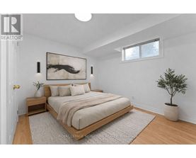 A bedroom with a bed, nightstand, and a painting on the wall.
