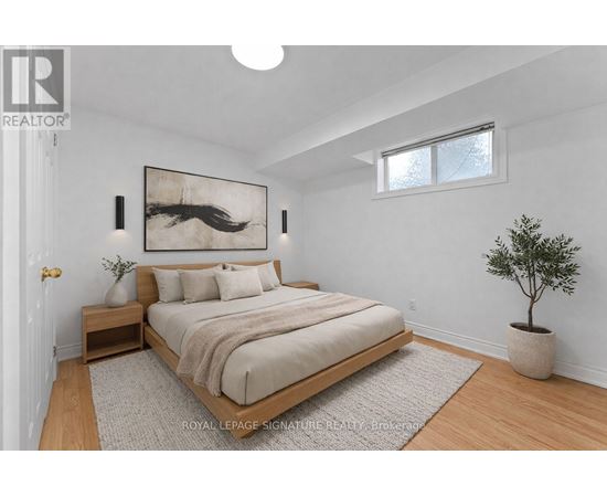 A bedroom with a bed, nightstand, and a painting on the wall.