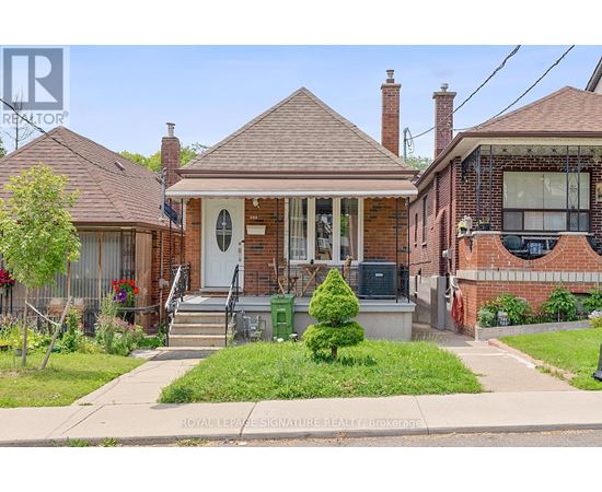 A small house with a front porch and a green bush.