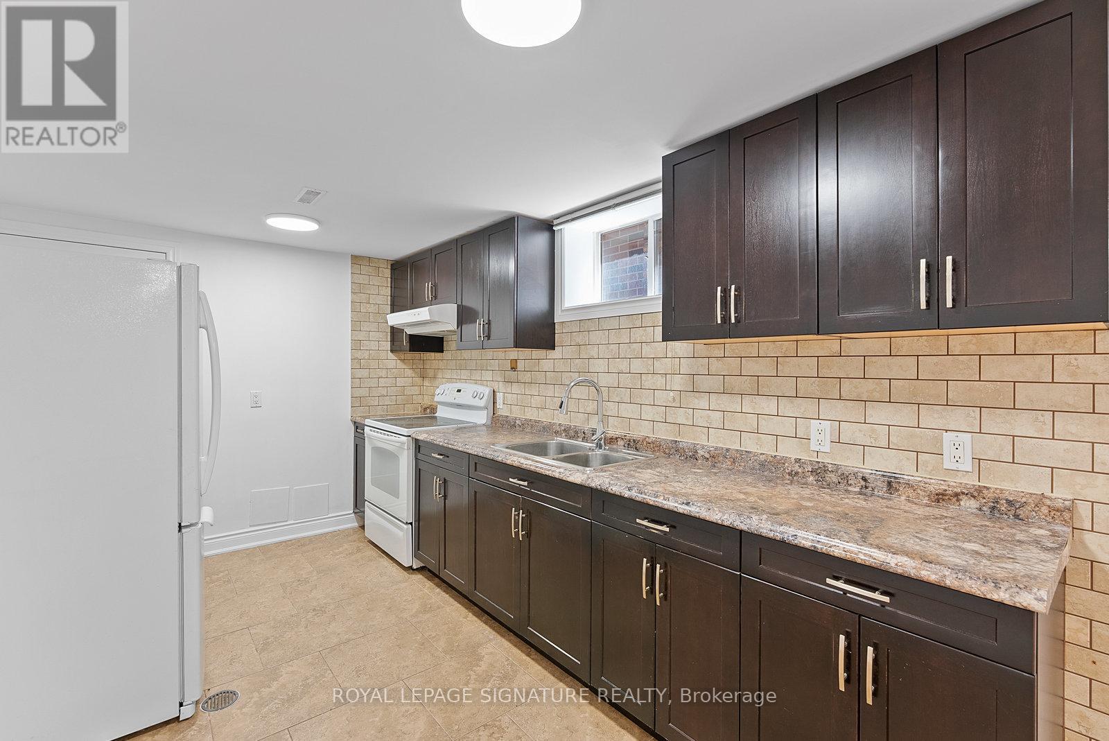 A kitchen with brown cabinets and a white refrigerator.