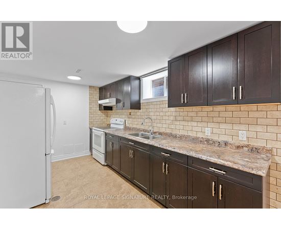 A kitchen with brown cabinets and a white refrigerator.