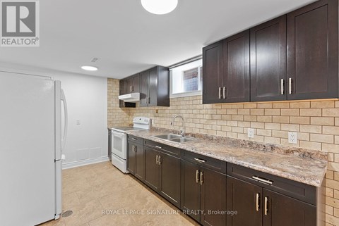 A kitchen with brown cabinets and a white refrigerator.