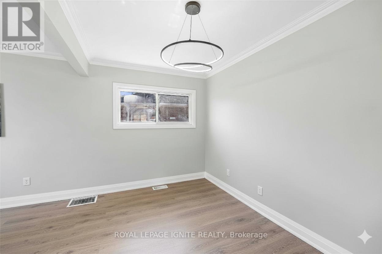 A room with a wooden floor and a picture hanging on the wall.