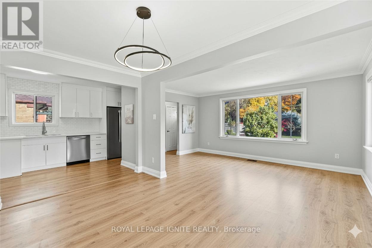 A spacious kitchen with white cabinets and a black refrigerator.