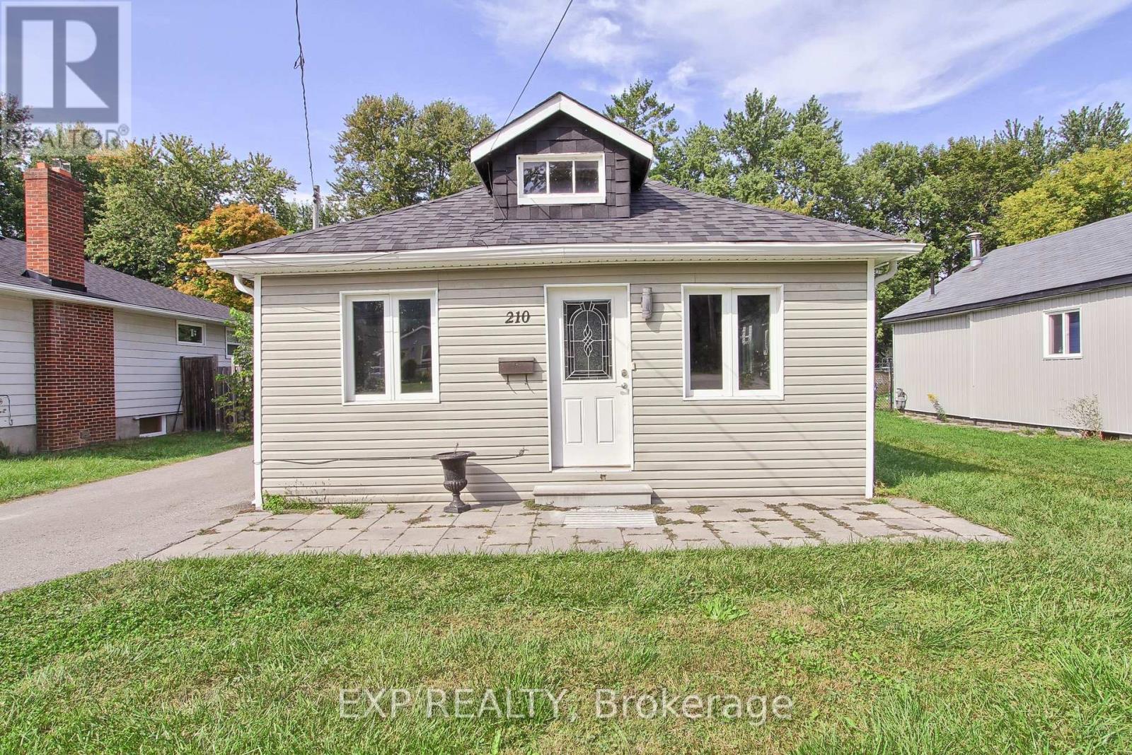 A small house with the number 210 on the front door.