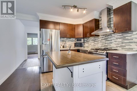 A modern kitchen with wooden cabinets and a stone backsplash.