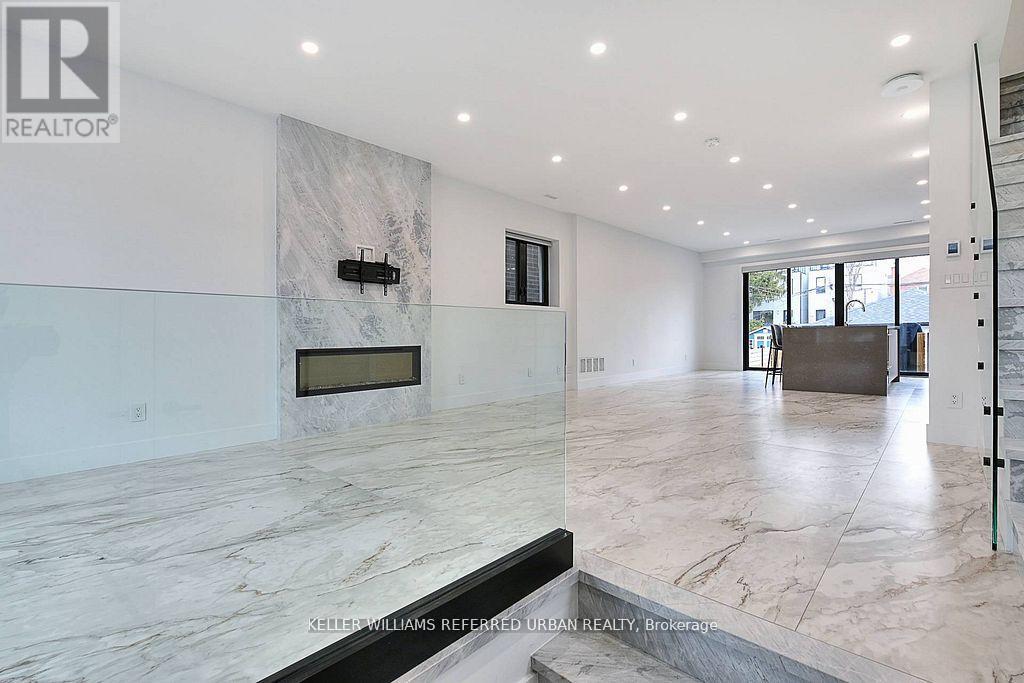 A spacious living room with a marble floor and a fireplace.