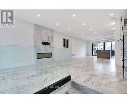 A spacious living room with a marble floor and a fireplace.