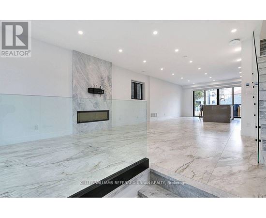 A spacious living room with a marble floor and a fireplace.