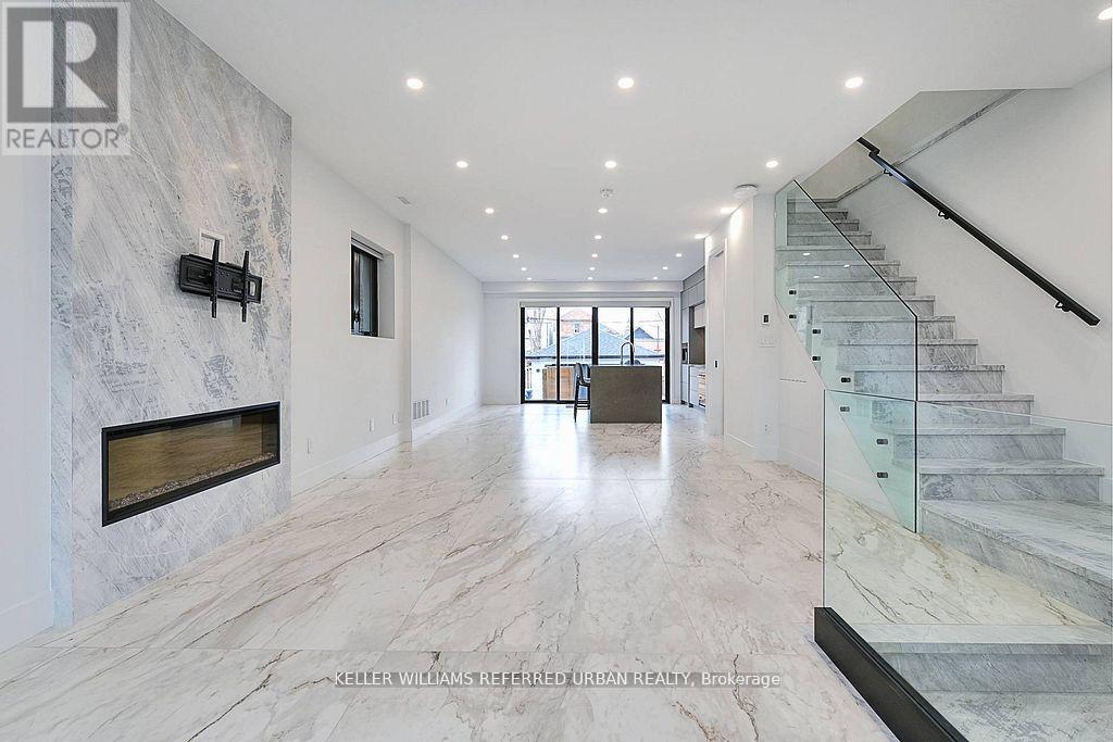 A spacious hallway with marble floors and a staircase.