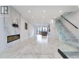 A spacious hallway with marble floors and a staircase.