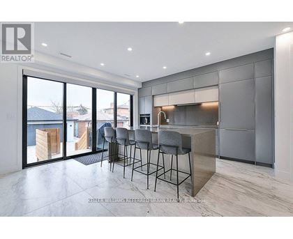 A modern kitchen with a bar area and a view of the outdoors.