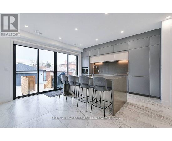 A modern kitchen with a bar area and a view of the outdoors.
