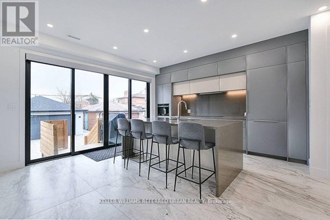 A modern kitchen with a bar area and a view of the outdoors.