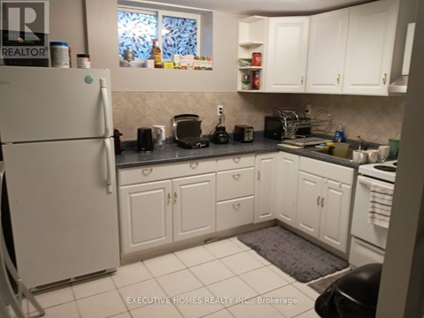 A kitchen with white cabinets and appliances.