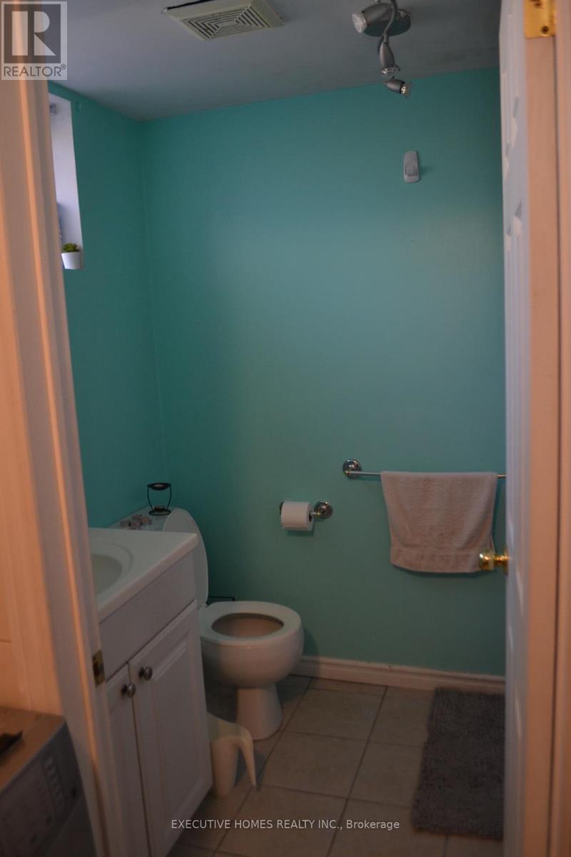 A bathroom with a toilet, sink, and towel rack.