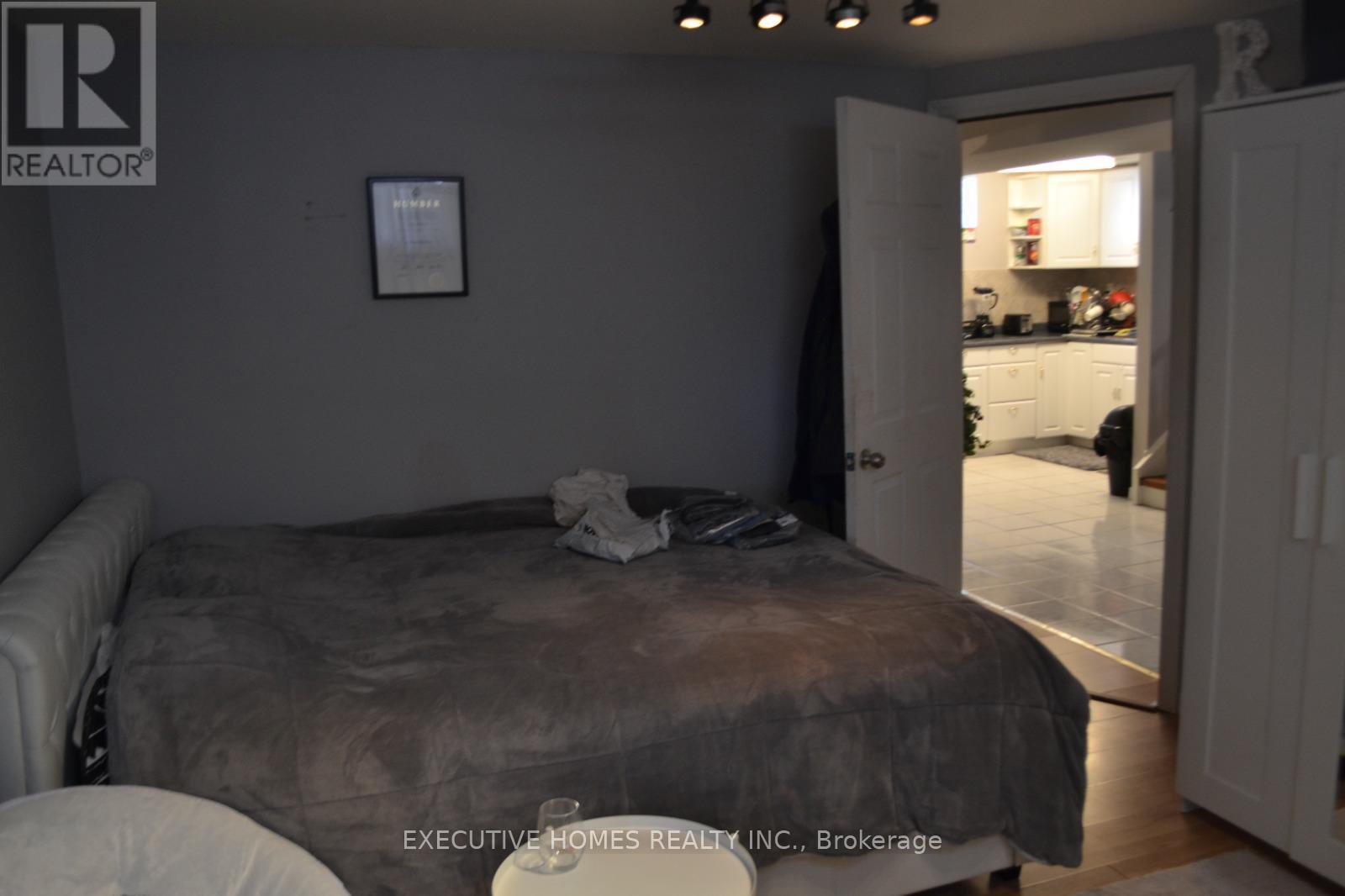 A bedroom with a bed and a picture on the wall.