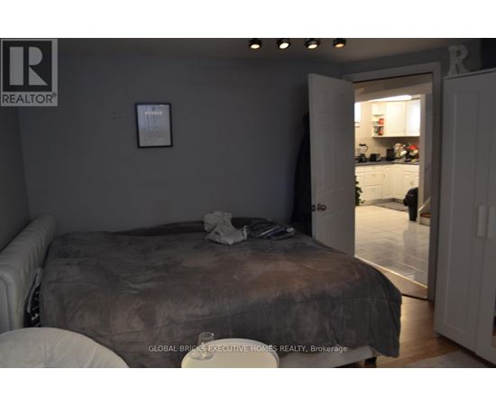 A bedroom with a bed and a picture on the wall.