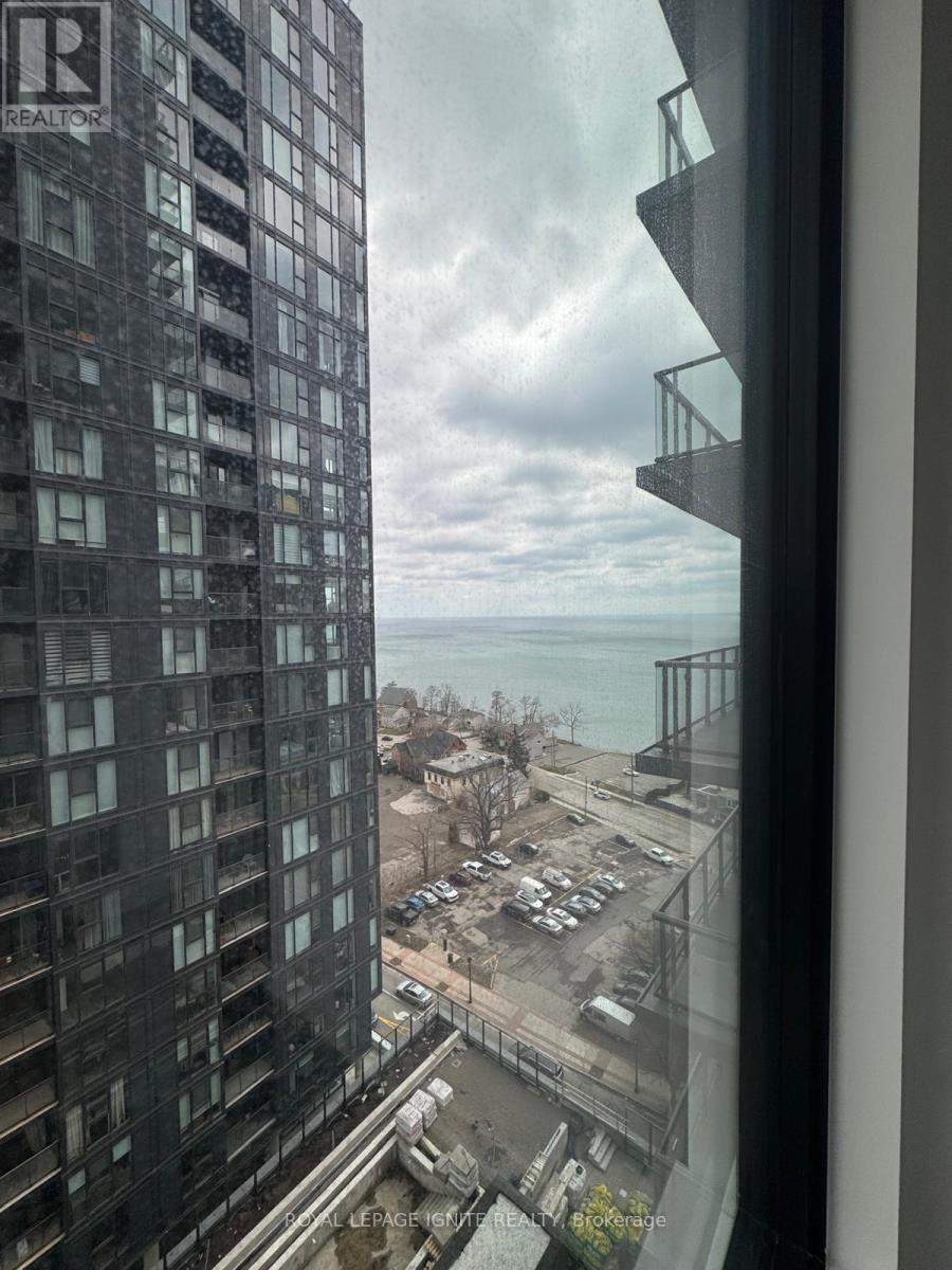 A view from a high-rise building looking out over a parking lot and a body of water.