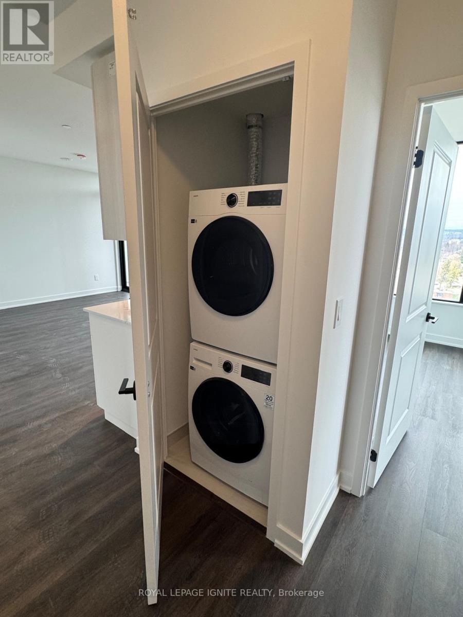 A white washer and dryer are stacked in a small space.