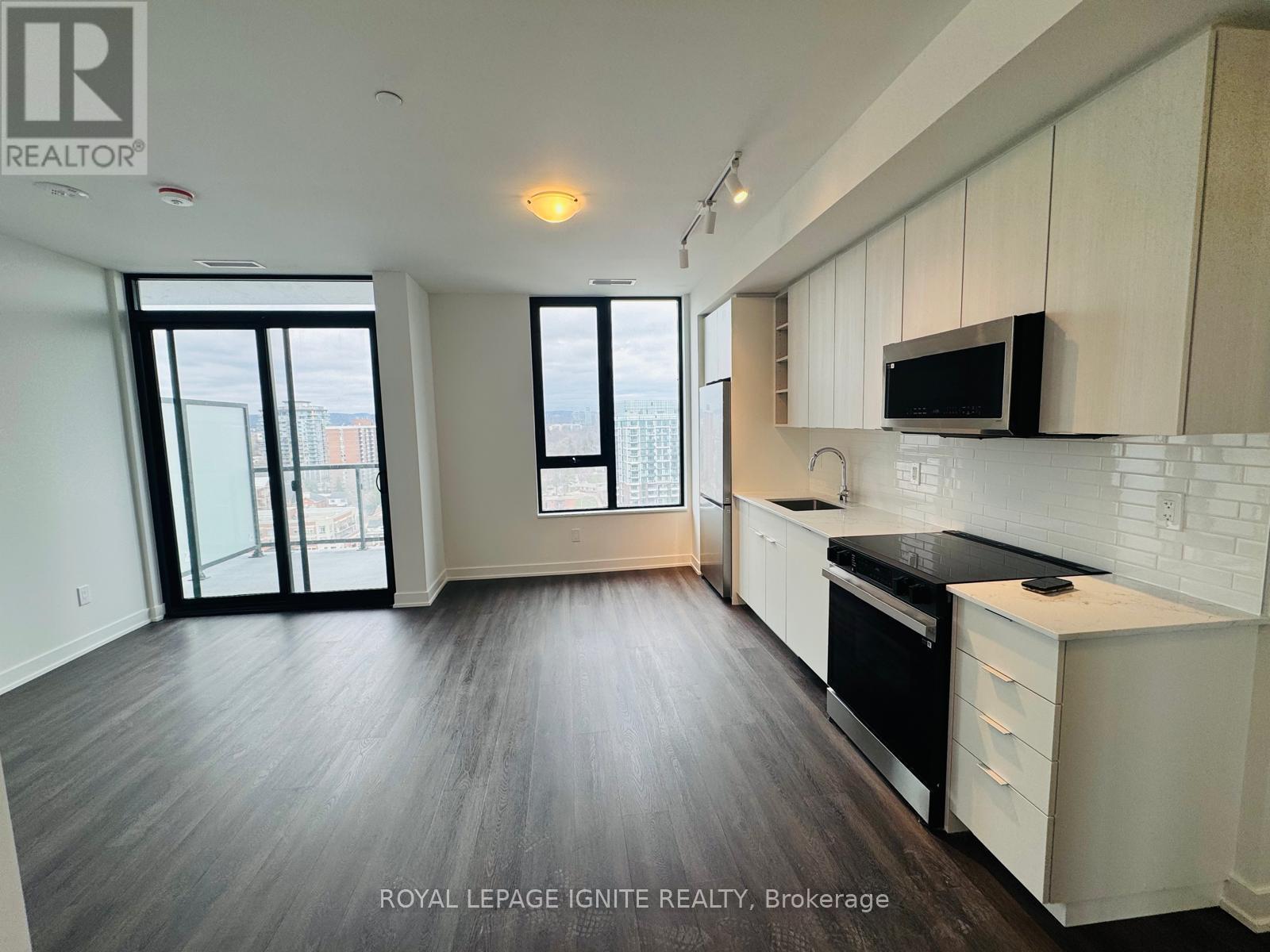 A kitchen with white cabinets and black appliances.