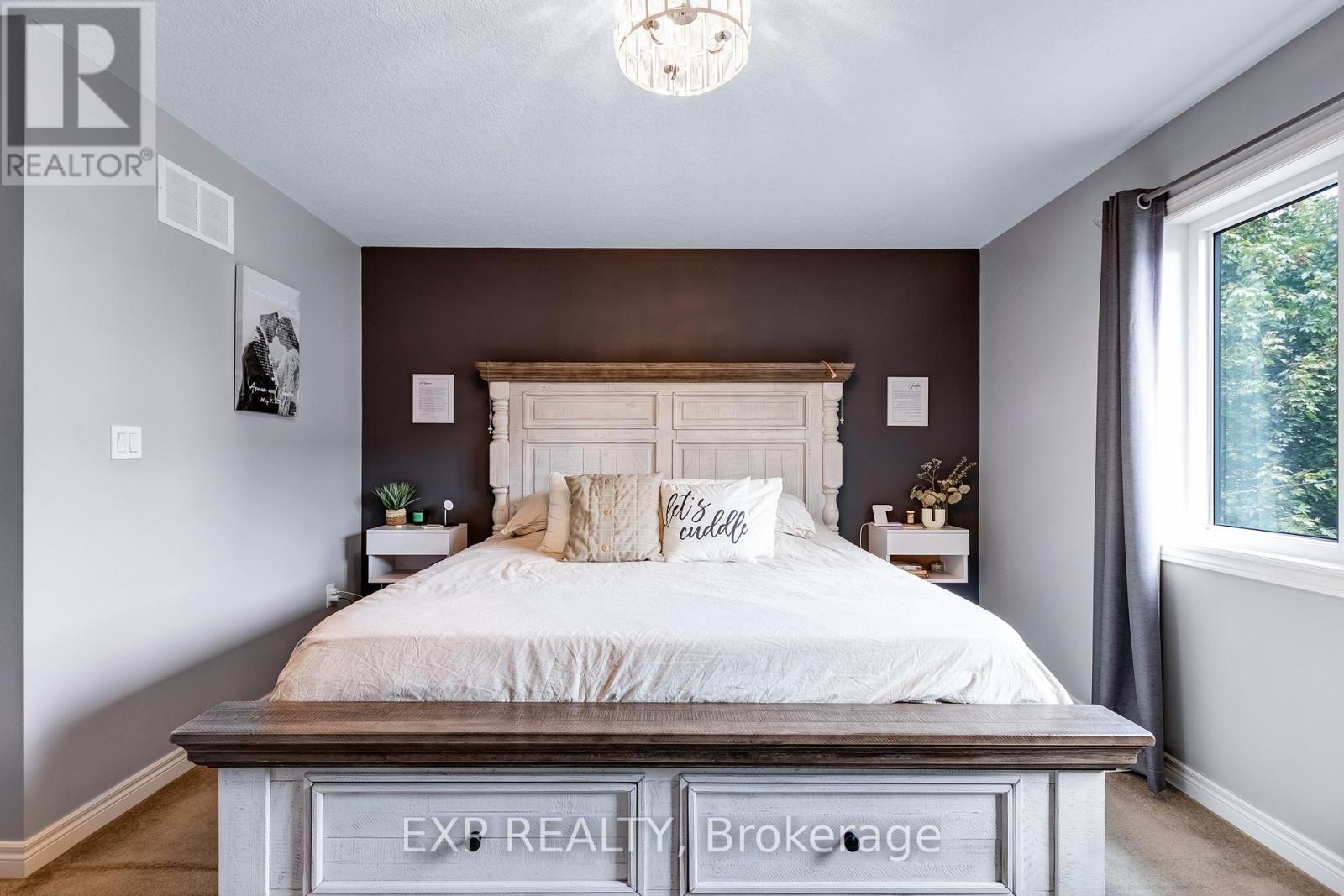A bedroom with a large bed and a chandelier.