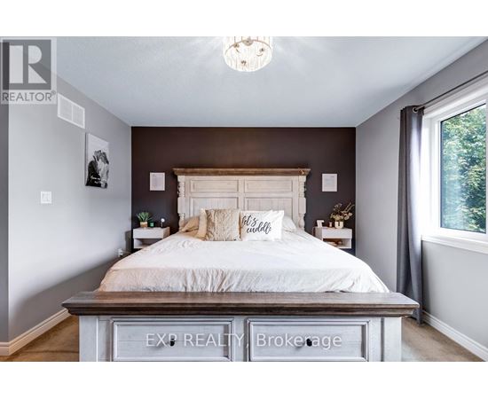 A bedroom with a large bed and a chandelier.