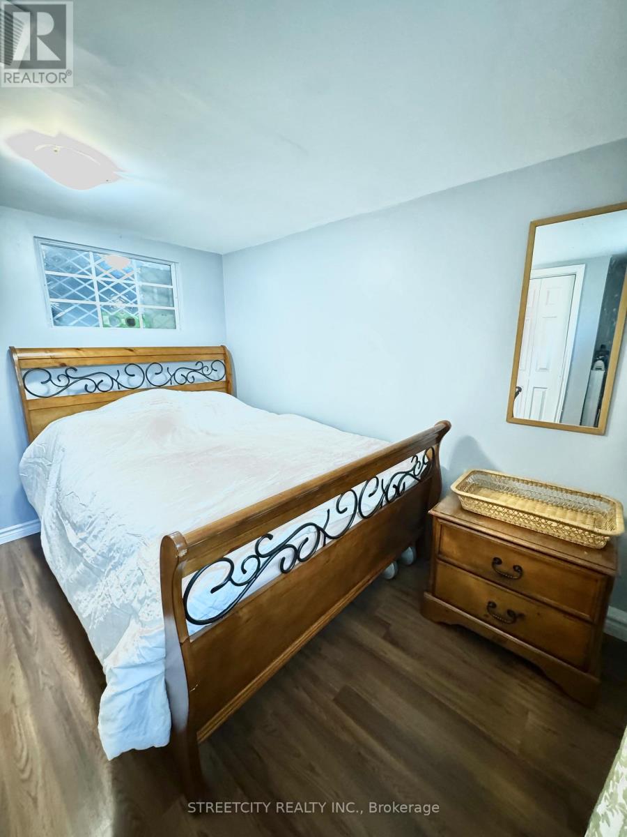 A bedroom with a bed, dresser and mirror.