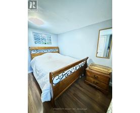 A bedroom with a bed, dresser and mirror.