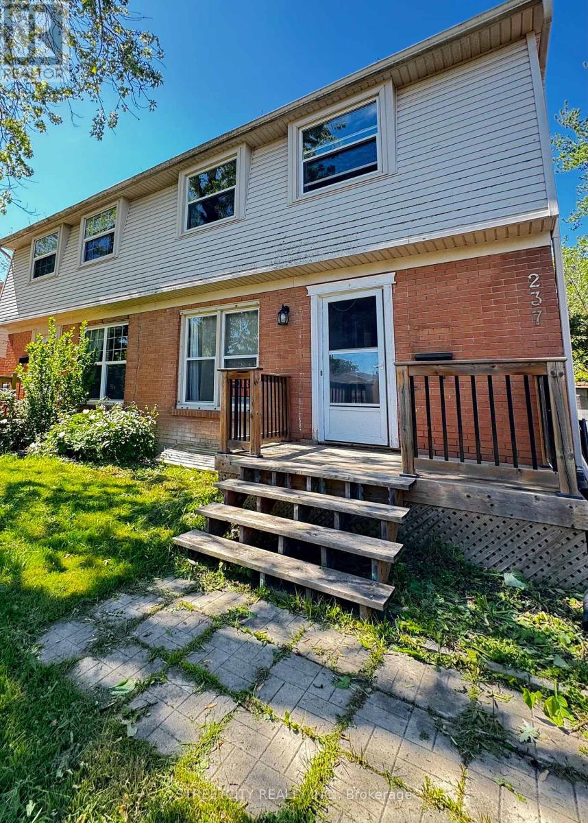 A house with a brick facade and a white siding is numbered 237.