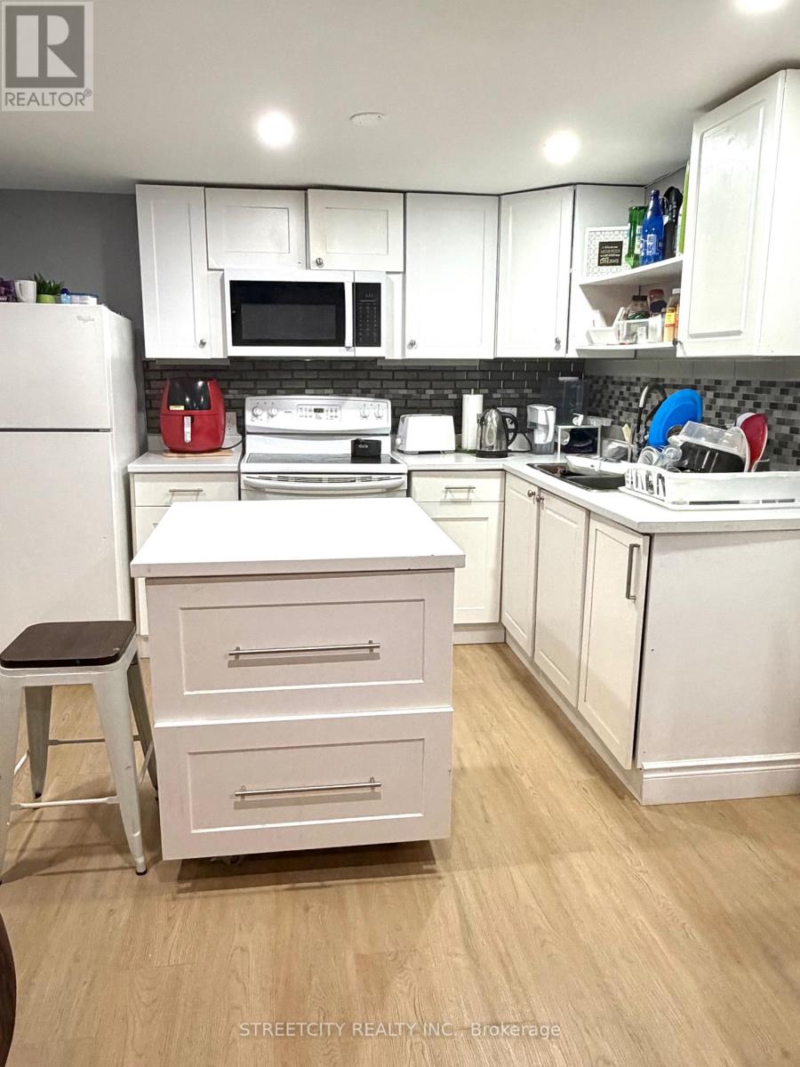 A kitchen with white cabinets and appliances.