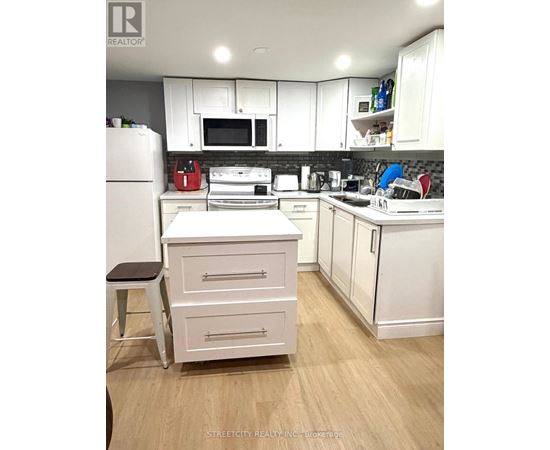 A kitchen with white cabinets and appliances.