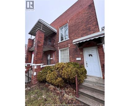 A red brick house with a white door and windows.
