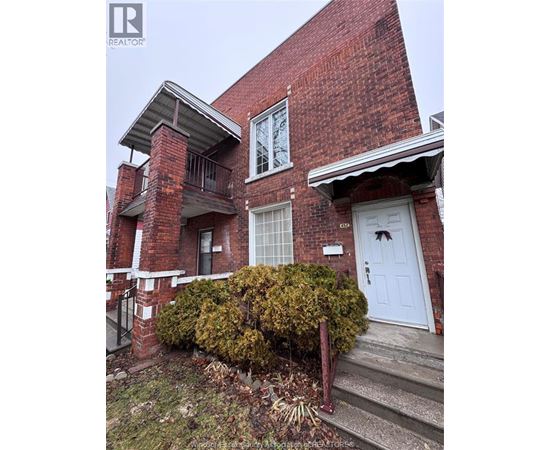 A red brick house with a white door and windows.