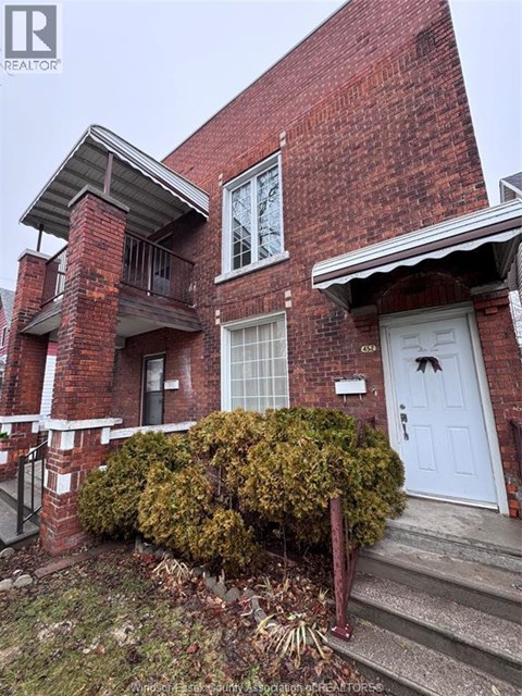 A red brick house with a white door and windows.
