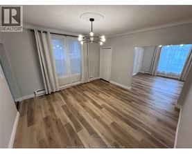 A room with wooden flooring and a chandelier.