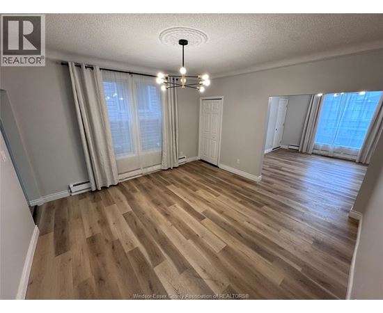 A room with wooden flooring and a chandelier.