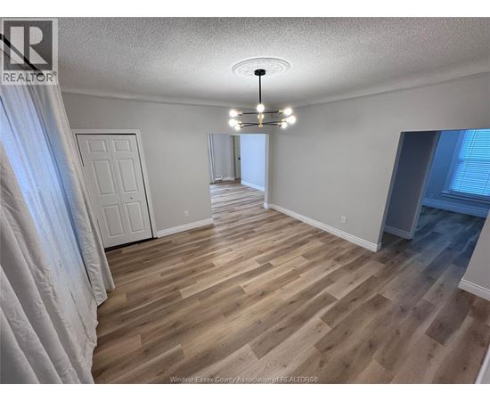 A room with wooden flooring and a white door.