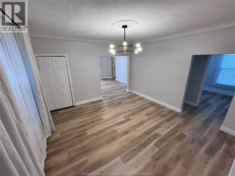 A room with wooden flooring and a white door.