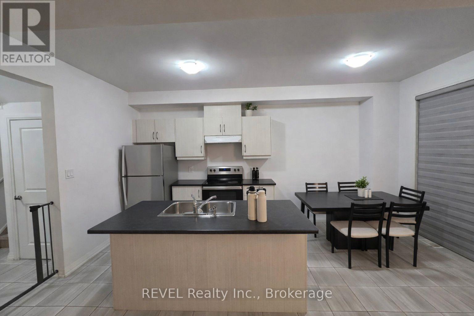 A kitchen with a black countertop and a dining table with chairs.