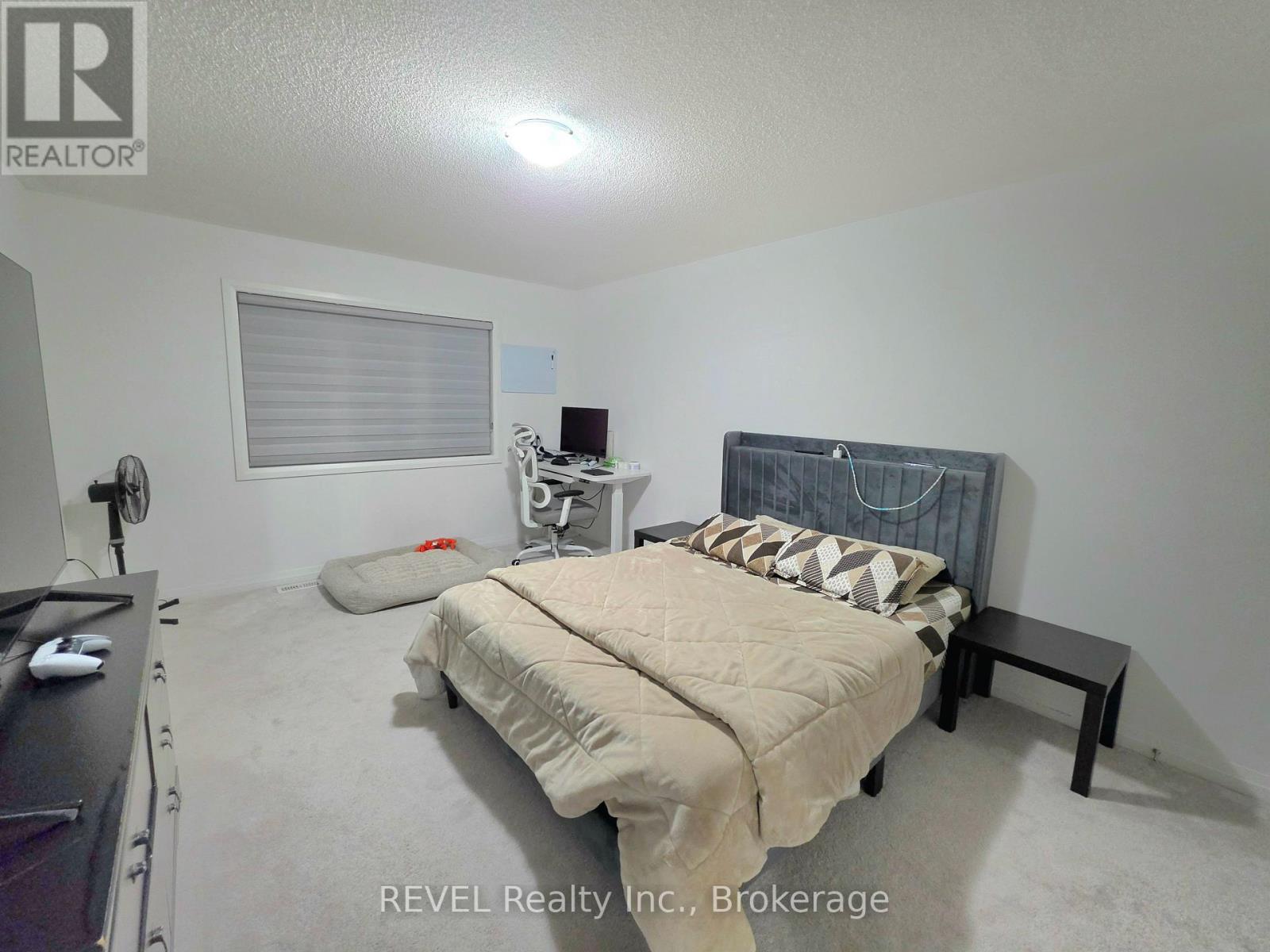 A bedroom with a bed, nightstand, and window.